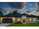 Charming one-story home featuring a two-car garage, manicured lawn, and inviting front entrance at twilight at 16947 Sw 22Nd Terrace Rd, Ocala, FL 34473