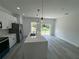Bright kitchen island features modern pendant lights and stainless steel appliances overlooking backyard at 16947 Sw 22Nd Terrace Rd, Ocala, FL 34473