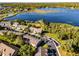 Wide aerial view of a lakeside townhome community with mature trees at 1968 Compass Flower Way, Ocoee, FL 34761