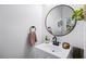 Powder room featuring a sleek vanity, a circular mirror, and modern fixtures providing style and functionality at 1968 Compass Flower Way, Ocoee, FL 34761