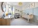 Charming Bedroom with a crib, dresser, rocking chair, and soft lighting for a cozy atmosphere at 1968 Compass Flower Way, Ocoee, FL 34761