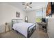 Cozy bedroom with a metal frame bed, a ceiling fan, a stylish full length mirror, and a functional desk area at 1968 Compass Flower Way, Ocoee, FL 34761