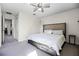 Bright bedroom features a ceiling fan, plush carpeting, and a queen bed with storage drawers at 1968 Compass Flower Way, Ocoee, FL 34761