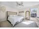 Light-filled bedroom with neutral tones, large window, and decorative mirror creating a cozy atmosphere at 1968 Compass Flower Way, Ocoee, FL 34761