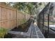 Landscaped backyard with a stone paver walkway, fenced in yard, and screened-in porch and pool at 204 Smokerise Blvd, Longwood, FL 32779
