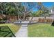 Landscaped backyard featuring an outdoor firepit with chairs, a large tree and green grass at 204 Smokerise Blvd, Longwood, FL 32779