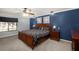 Comfortable bedroom featuring a king-size bed, modern furniture, and a calming blue accent wall at 204 Smokerise Blvd, Longwood, FL 32779