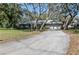 Long driveway leads to this home's attached garage, set amidst a backdrop of lush lawn and mature trees at 204 Smokerise Blvd, Longwood, FL 32779