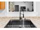 Close-up of a stainless steel kitchen sink with black fixtures and natural stone elements in the background at 204 Smokerise Blvd, Longwood, FL 32779