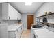 Laundry room with geometric wallpaper, white cabinets, and modern washer/dryer at 204 Smokerise Blvd, Longwood, FL 32779