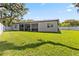 View of a modern home's backyard with a screened-in lanai, white privacy fence, and spacious lawn at 2058 Washington Ave, Sanford, FL 32771