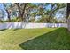 Expansive backyard with lush green grass, surrounded by a white vinyl privacy fence and mature shade trees at 2058 Washington Ave, Sanford, FL 32771