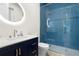 Sleek bathroom with navy blue vanity, modern sink, mirrored shower with light, and blue tile at 2058 Washington Ave, Sanford, FL 32771