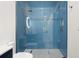 Modern bathroom featuring a frameless shower with light, rain shower head, and blue tile at 2058 Washington Ave, Sanford, FL 32771
