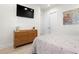 Modern bedroom featuring a dresser, TV, soft gray bedding, and natural light from the large window at 2058 Washington Ave, Sanford, FL 32771