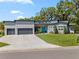 Stunning one-story home featuring a sleek design, modern garage doors, and a vibrant blue front door at 2058 Washington Ave, Sanford, FL 32771