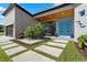 Welcoming front entrance showcases a modern design with a vibrant blue door, pavers, and stylish landscaping at 2058 Washington Ave, Sanford, FL 32771