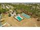 Aerial view of community pool and tennis courts with green space, trees and neighborhood homes at 229 Troon Cir, Davenport, FL 33897