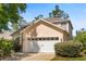 Charming two-story home featuring a two-car garage, light peach exterior, and a well-maintained landscaped yard at 229 Troon Cir, Davenport, FL 33897