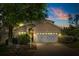 Charming single-Gathering home with a well-manicured lawn and an attached two-car garage at dusk at 229 Troon Cir, Davenport, FL 33897