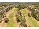 An aerial view of a lush golf course community featuring mature trees and well-maintained fairways at 229 Troon Cir, Davenport, FL 33897