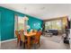 Open-concept living and dining area with modern furnishings and bright, teal accent walls at 229 Troon Cir, Davenport, FL 33897