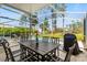 Outdoor patio with dining table, chairs, BBQ grill, and pool in the background at 229 Troon Cir, Davenport, FL 33897