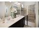 Bathroom featuring a double vanity, sleek mirrors, and a glass-enclosed shower with elegant tiling at 2327 Distant Sun Trl, Kissimmee, FL 34747