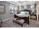 A well-lit bedroom features a large window, tray ceiling, and a beautifully adorned wood bed at 2327 Distant Sun Trl, Kissimmee, FL 34747