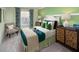 Inviting bedroom with green walls, decorative pillows, and ample natural light creating a peaceful retreat at 2327 Distant Sun Trl, Kissimmee, FL 34747