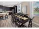 A dining room features a dark wood table and chairs near a modern kitchen with stainless steel appliances at 2327 Distant Sun Trl, Kissimmee, FL 34747