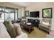 Cozy living room with comfortable seating, a large TV, and sliding glass doors to an outdoor patio at 2327 Distant Sun Trl, Kissimmee, FL 34747