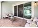 Covered patio with brick flooring, comfortable seating, and sliding glass doors overlooking the pool area at 2327 Distant Sun Trl, Kissimmee, FL 34747