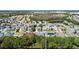 An aerial view showcases homes with a pond and trees nearby, set within a suburban community at 2501 Hinsdale Dr, Kissimmee, FL 34741