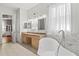 Bright and airy bathroom with double sinks, soaking tub, and marble tiled walls at 2501 Hinsdale Dr, Kissimmee, FL 34741