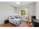 A bedroom features a ceiling fan, wood floors, gray walls, and a window with curtains at 2501 Hinsdale Dr, Kissimmee, FL 34741