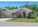 Charming single-story home with a well-manicured lawn, three-car garage and complemented by swaying palm trees at 2501 Hinsdale Dr, Kissimmee, FL 34741