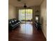 Living room with ceiling fan, hardwood flooring, access to screened porch and built in shelves at 2717 Maitland Crossing Way # 4-103, Orlando, FL 32810