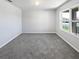 Empty bedroom features neutral carpet, white walls, and a large window providing natural light at 3056 Sangria St, Kissimmee, FL 34744