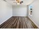 Bright bedroom with wood-look floors, ceiling fan, and window at 3056 Sangria St, Kissimmee, FL 34744