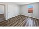 Bedroom with wood-look flooring, a window, and white door at 3056 Sangria St, Kissimmee, FL 34744