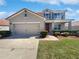 Two-story home with red tile roof, tan exterior, blue shutters, landscaping, and a two car garage at 3056 Sangria St, Kissimmee, FL 34744