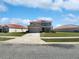 Two-story home with red tile roof, tan exterior, blue shutters, landscaping, and a two car garage at 3056 Sangria St, Kissimmee, FL 34744