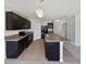 Kitchen features dark cabinetry, granite countertops, tiled flooring, and modern appliances at 3056 Sangria St, Kissimmee, FL 34744
