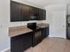 Close up view of kitchen featuring black appliances, dark wood cabinets, and laminate countertops at 3056 Sangria St, Kissimmee, FL 34744