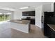Kitchen features black appliances, dark cabinetry and an island with a double basin sink at 3056 Sangria St, Kissimmee, FL 34744
