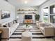 Bright living room featuring a plush rug, comfortable seating, and stylish shelving over the entertainment center at 3056 Sangria St, Kissimmee, FL 34744