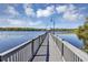 A long wooden dock leading to a gazebo on a lake with trees in the background at 3398 Greenwich Village Blvd # 104, Orlando, FL 32835