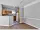 Open living space featuring wood floors, white trim, and a partial view of the kitchen and stainless appliances at 3398 Greenwich Village Blvd # 104, Orlando, FL 32835
