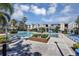 Resort-style pool with surrounding lounge chairs, community buildings and a lush tropical landscape at 3398 Greenwich Village Blvd # 104, Orlando, FL 32835